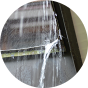 雨樋の継ぎ目から勢いよく水が漏れ出ている様子