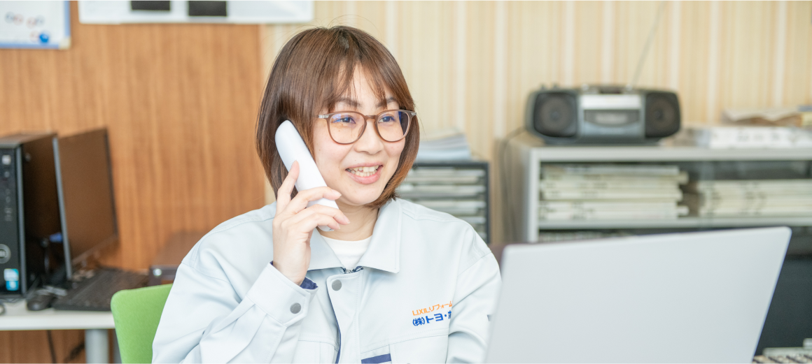 女性スタッフが電話対応しながらパソコン作業をしているオフィス風景