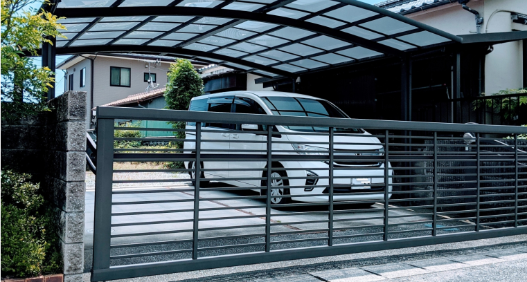 白いミニバンが停車したカーポート付きの住宅駐車スペース