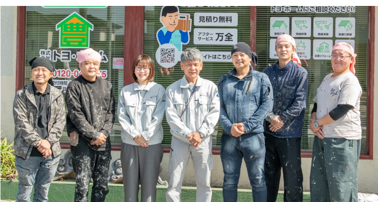 建物の前で集合写真を撮るスタッフたち、笑顔で並んだグループ