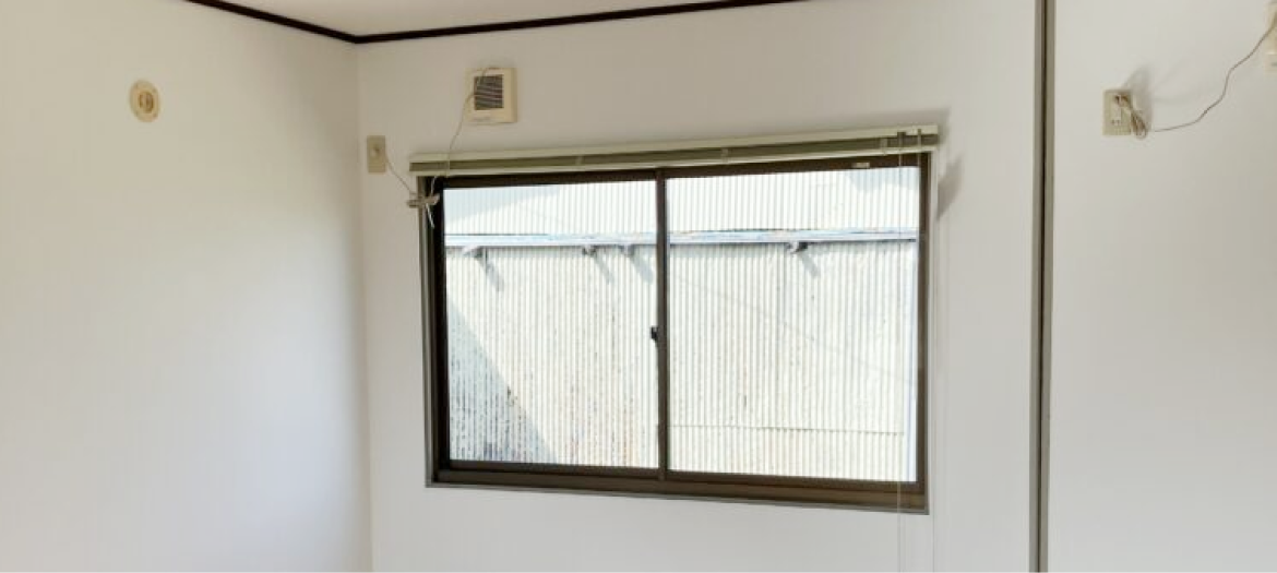 壁に換気扇とコード類が見える、何もないシンプルな空室