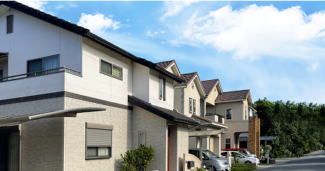 青空の下に整然と並ぶ新築または塗装済みの戸建住宅街の景観